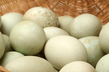 duck eggs in a basket on white.