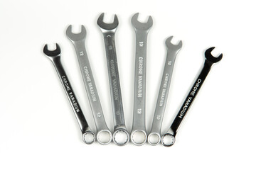 a group of new metal wrenches for tightening bolts and nuts on a white background