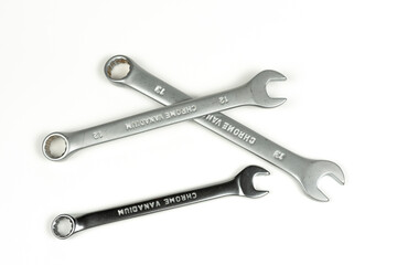 a group of new metal wrenches for tightening bolts and nuts on a white background