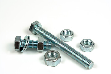 several metal washers, nuts and bolts of silver color on a white background. close-up