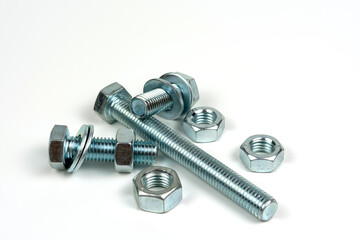 several metal washers, nuts and bolts of silver color on a white background. close-up