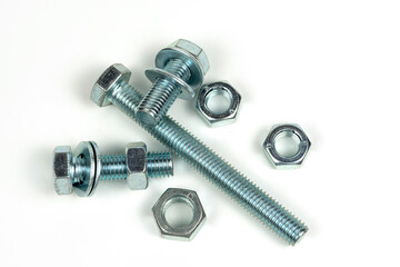 several metal washers, nuts and bolts of silver color on a white background. close-up