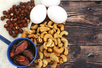 Bananas, eggs, strawberries, and cashew nuts under a blue background. Top view