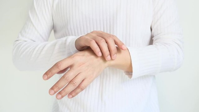 The man touches the wrist and thumb. He squeezes the knuckle of the thumb and wrist. He suffered a tendon injury, arthritis in his wrist, and de quervain disease.