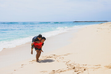 Play with family. Father carrying his son on the beach. vacation with family. Father and son game