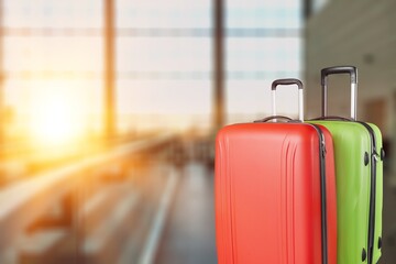 Modern stylish suitcases standing in empty airport hall, unrecognizable traveller's luggage