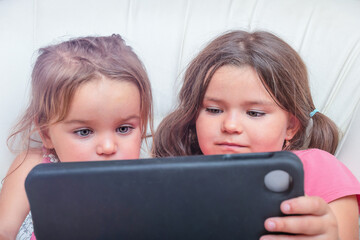 Children enthusiastically watching a tablet together