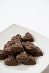 vertical photo of heart chocolates on white background