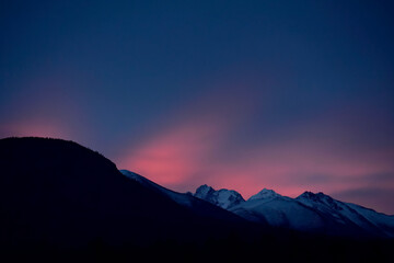 Fototapeta na wymiar Sunrise colors the morning sky over Alaska's Chugach Range. 