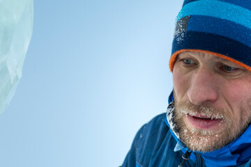 Portrait of a builder in a blue knitted hat and blue winter jacket