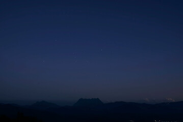 Fototapeta na wymiar Orion constellation on twilight sky over a mountain silhouette in a sunset time