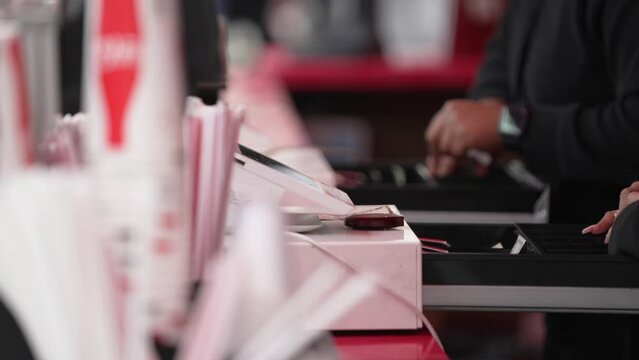 This close up video shows a row of anonymous busy food service cashier hands using cash registers to serve customers.