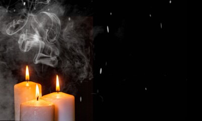 Candles over dark background. Used, almost extinguished. Burned out. Mystical smoke swirls in the...