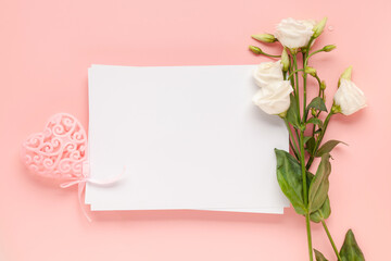 A sheet of paper lies horizontally on pink background, flowers of eustoma (lisianthus) Top view, Copy space. Concept Mother's Day, Family Day, Valentine's Day