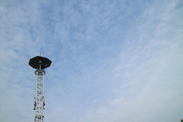 a high lamppost under a bright cloud