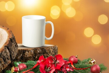 White mug on a wooden background with bright lights in the background. New Year and Christmas.