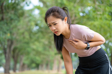 Exhausted female runner suffering painful angina pectoris or asthma breathing problems after training hard on summer. - obrazy, fototapety, plakaty