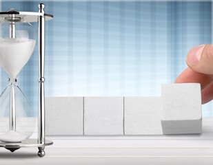 hand flipping block with hourglass on table. Resolution, time, plan, goal, motivation, reboot, countdown and New Year holiday concepts