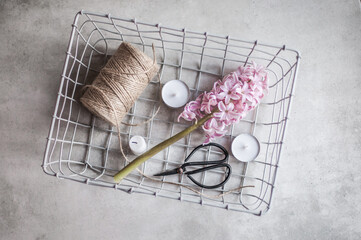 Gray metal basket with decor elements on a gray photo background