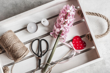 White wooden tray red heart and a pink hyacinth flowers on a tray.