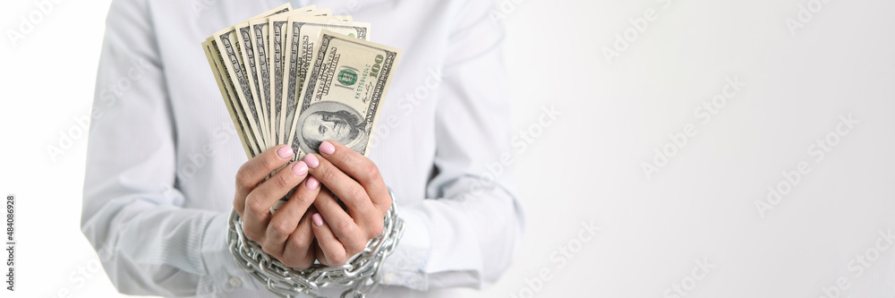 Wall mural women hands tied with chain hold one hundred dollar bills