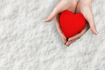 Person holding white heart in palm. Organ donation and insurance concept.