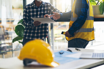 Concept architects, engineer holding pen pointing equipment architects On the desk with a blueprint...