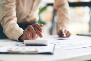 businessman working on desk office with using a calculator to calculate the numbers, finance accounting concept