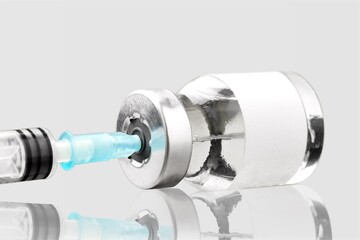 Obraz premium New COVID-19 variant a medical syringe and a vial on a background.