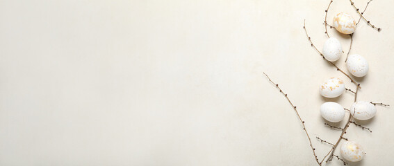 Beautiful Easter eggs and tree branches on light background with space for text