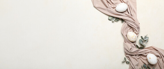 Composition with beautiful Easter eggs and eucalyptus branches on light background with space for text