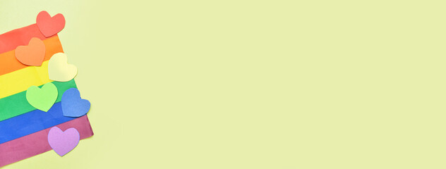 Colorful paper hearts with LGBT flag on color background with space for text