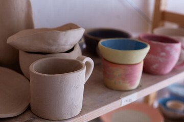 Fototapeta na wymiar Empty handmade tableware. ceramic cups on the shelf. Handmade work