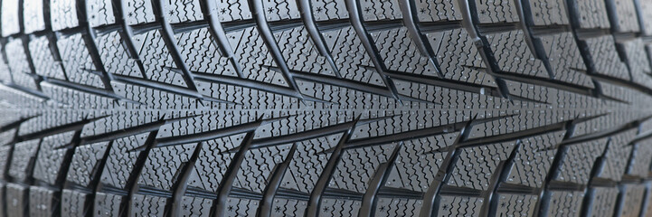 Stack of new black car tires with tread closeup