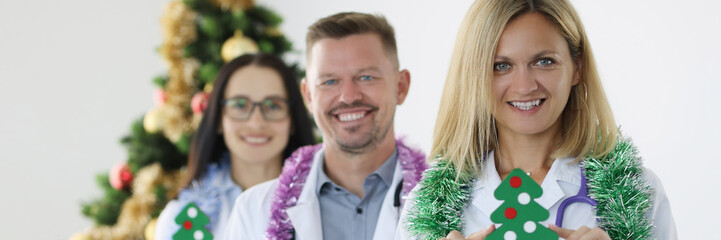Fototapeta premium Team of smiling doctors are holding calendar for 2022 and Christmas tree