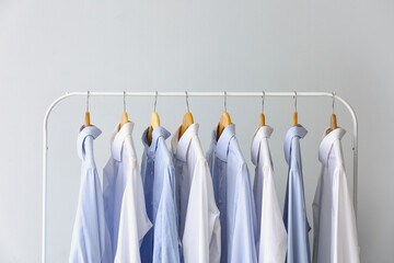 Rack with clean shirts on grey background