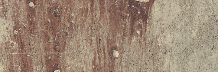 Vintage wall texture. Rough surface of the concrete wall, painted in brown. Pattern with rough brush strokes of paint. Wide panoramic texture for background and design.