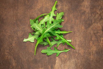 Ruccola leaf on wooden table, heap of fresh green arugula leaves collection top view..
