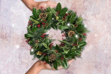 florist hands holding Christmas wreath. Christmas wreath workshop.