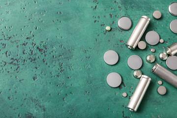 Different metal batteries on green background