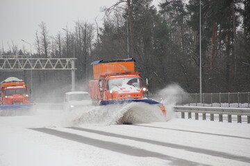 Snow plow trucks work on the highway to remove snow after the heavy snowfall