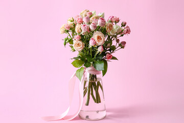 Vase with bouquet of beautiful roses on pink background