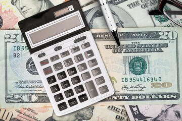 Fototapeta premium Money banknotes on a wooden table with a calculator Economics and financial planning