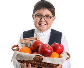 Little Jewish boy with gragger for Purim holiday and fruits in basket on white background