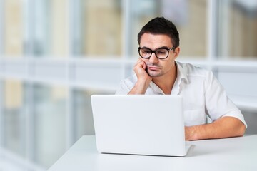 Portrait of happy freelancer man sitting with laptop computer at home office