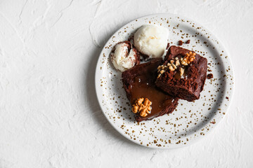 Plate with pieces of tasty chocolate brownie and ice cream on white background