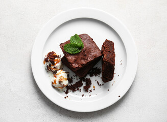Plate with pieces of tasty chocolate brownie and ice cream on white background