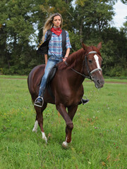 Beautiful cowgirl ride horseback in autumn forest
