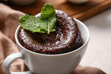 Cup with tasty chocolate brownie on table, closeup
