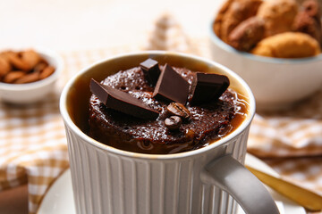 Cup with tasty chocolate brownie on table, closeup